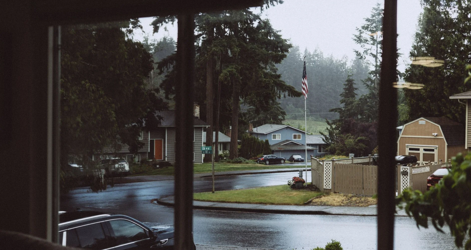 Rainy day view of a quiet suburban street through a window