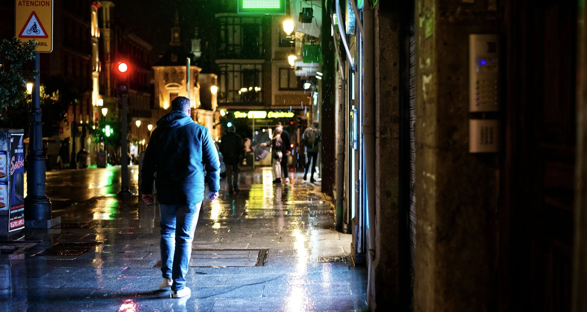 Rain on a city shopping street at night