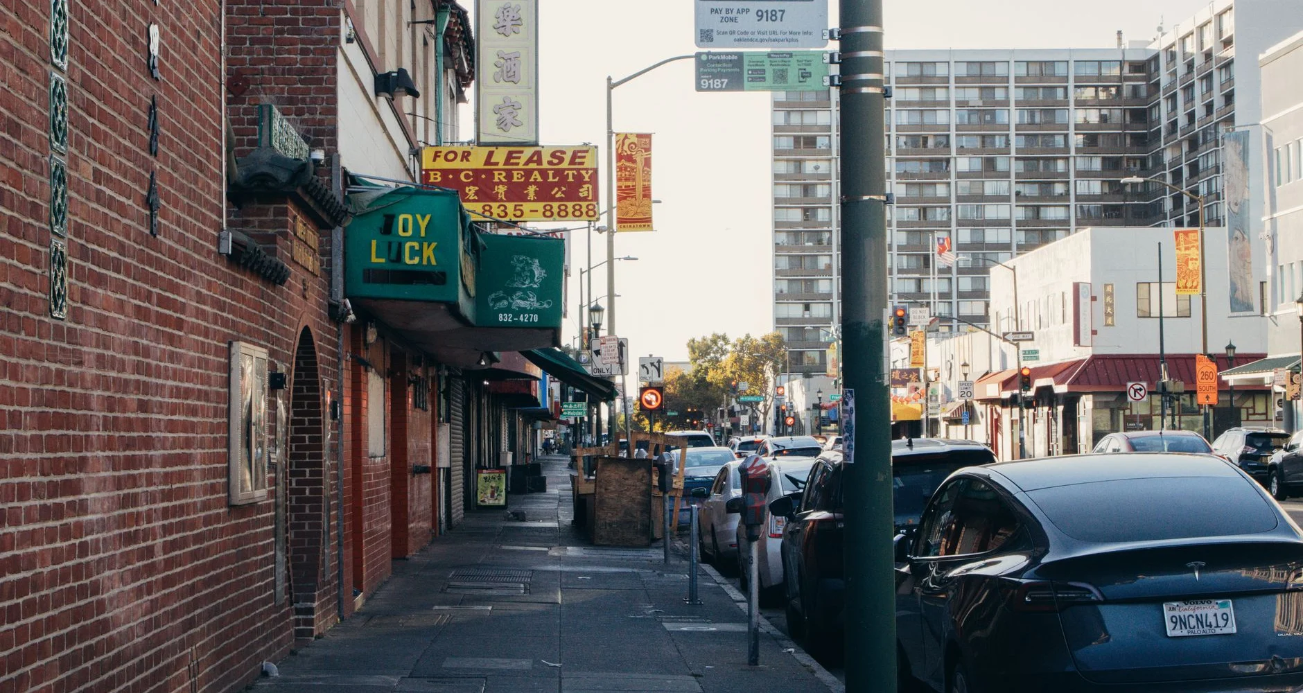 City street with older brick buildings and parked cars
