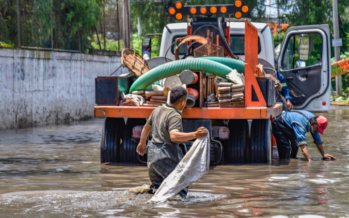 Pump truck crew removing floodwater from a flooded street